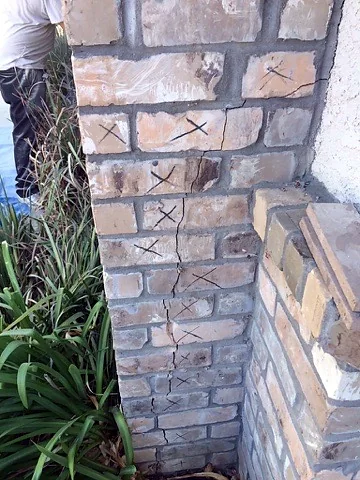 Before: Cracked brick corner marked for replacement
